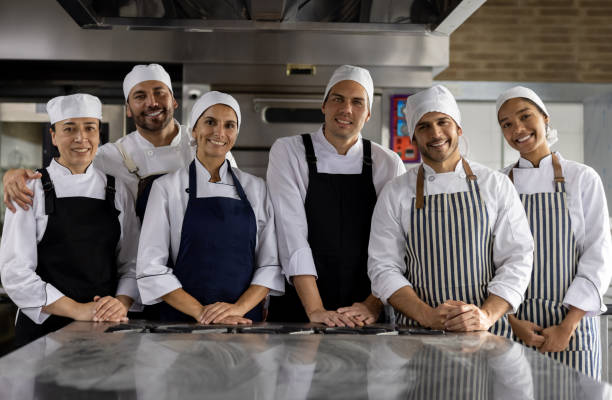 Group of Latin American students in a cooking class learning about baking and looking at the camera smiling